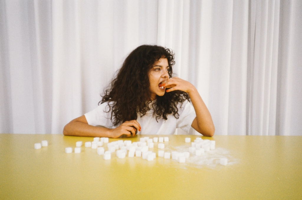 Woman eating tons of sugar cubes