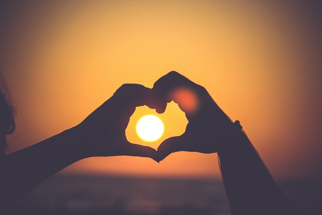 Two people making heart pose