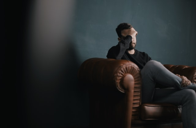 A man sitting alone on a sofa