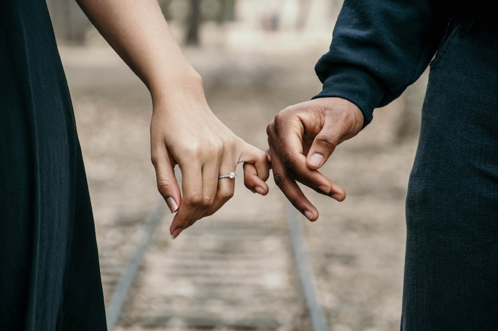 A couple holding each other’s pinky fingers.