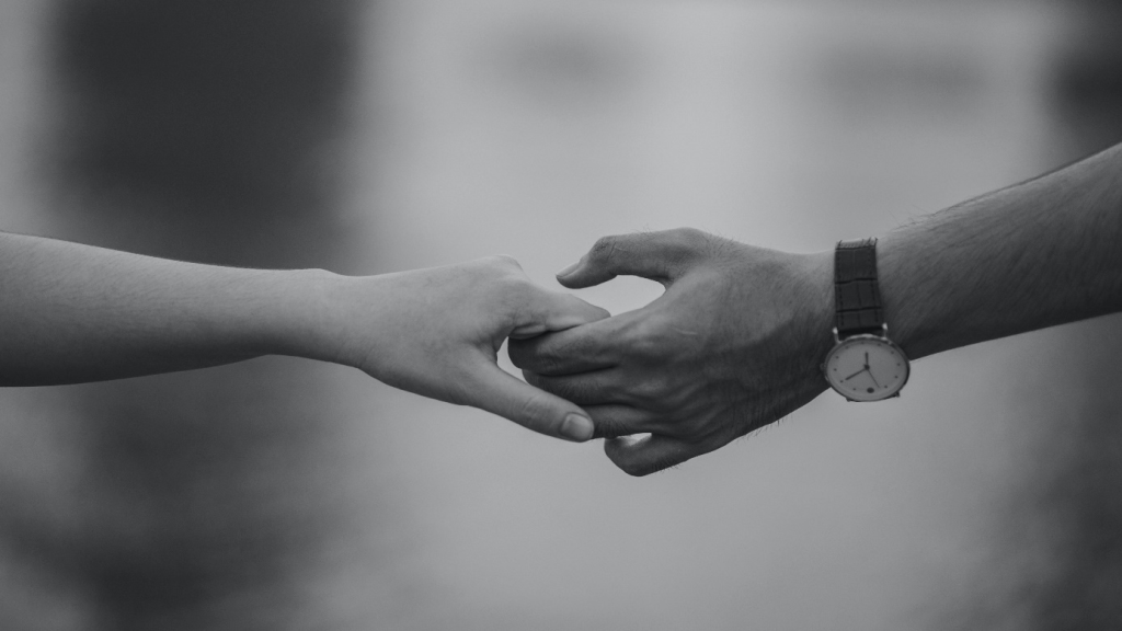 A couple holding hands with each other.