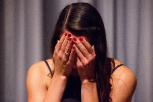 A woman covering her face with her hands